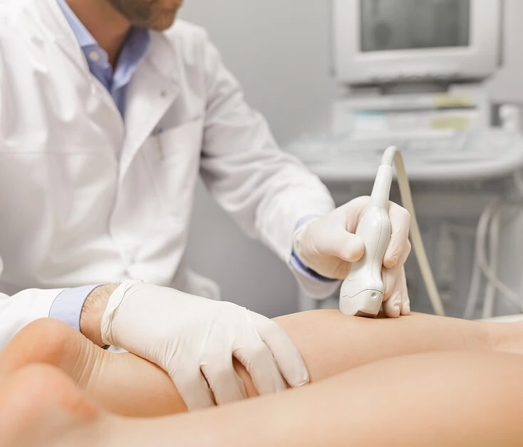 A vein specialist in Boca Raton performs a varicose vein ultrasound treatment.
