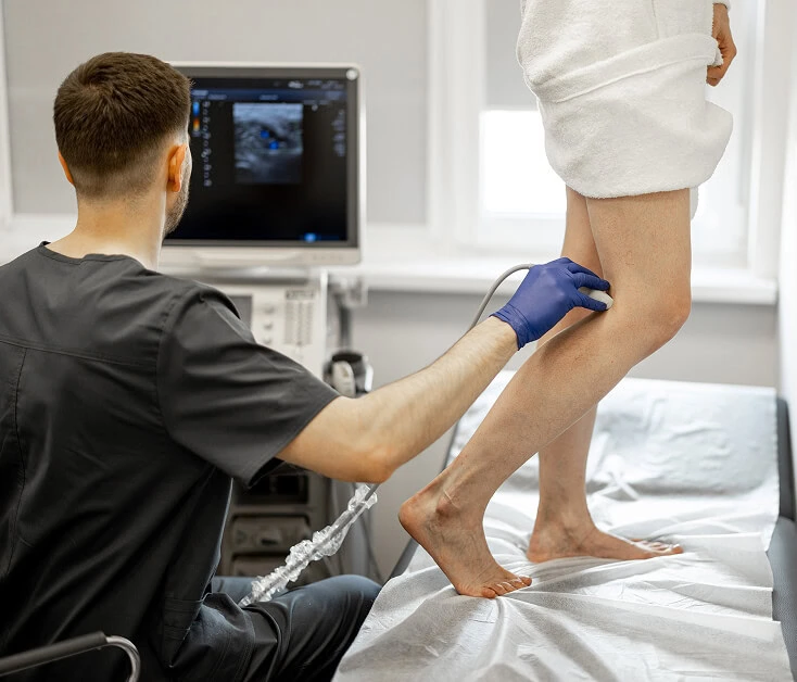 Vein specialist at Boca Raton vein center performs ultrasound for varicose vein diagnosis.