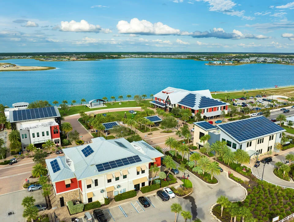 Aerial view of Boca Raton vein treatment center near lake, palm trees, and modern buildings.